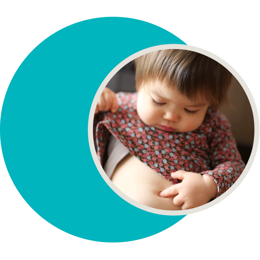 Circle image of a baby with brown hair poking her belly button